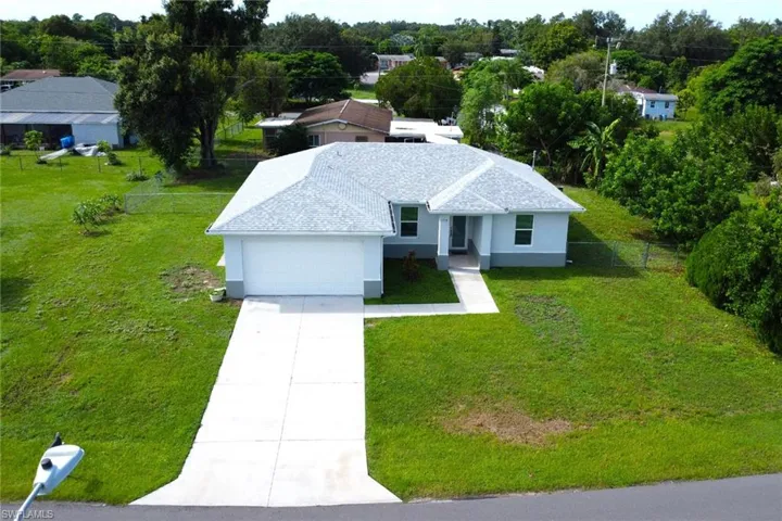 Ranch-style home featuring stucco siding, driveway, an attached garage, and roof with shingles
