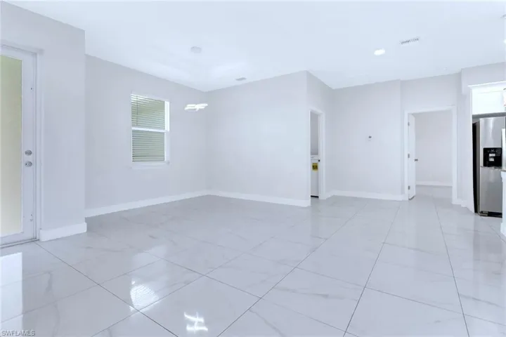 Spare room with healthy amount of natural light and a chandelier