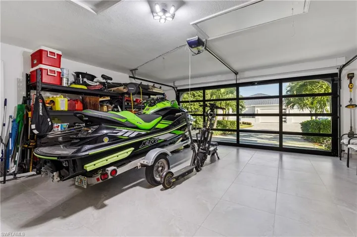Garage with a glass garage door and ceramic tile flooring