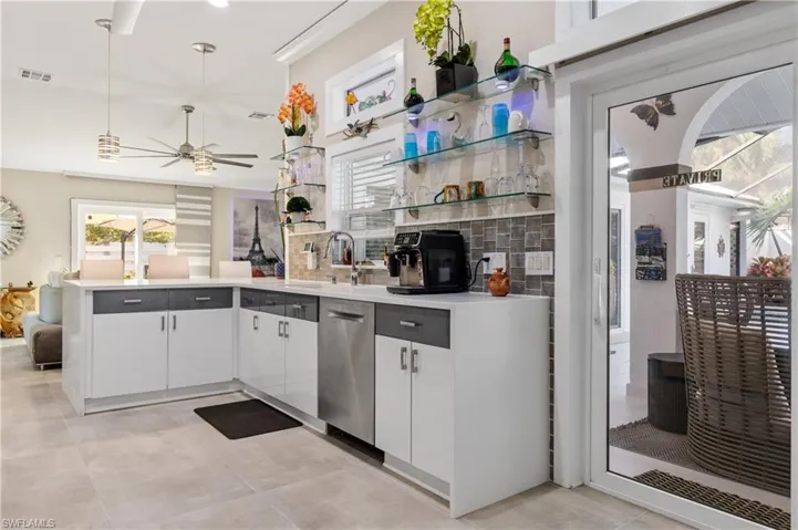Kitchen with open shelves, a peninsula, white cabinets, dishwasher,