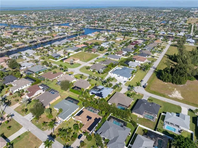 Aerial view of property and surrounding area with nearby suburban area and a large body of water (Pine island sound)