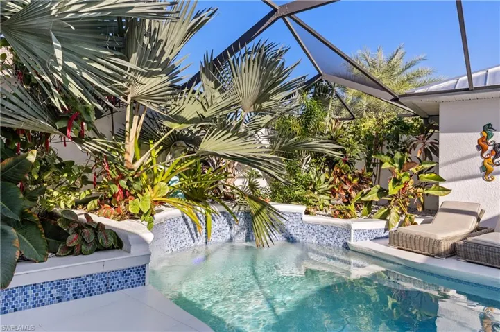 Outdoor pool featuring waterfall and lanai