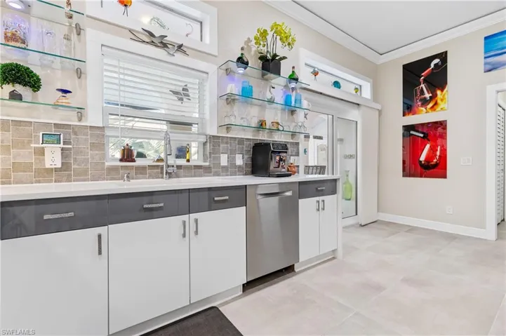 Kitchen featuring open shelves, crown molding, dishwasher, white cabinets, and backsplash