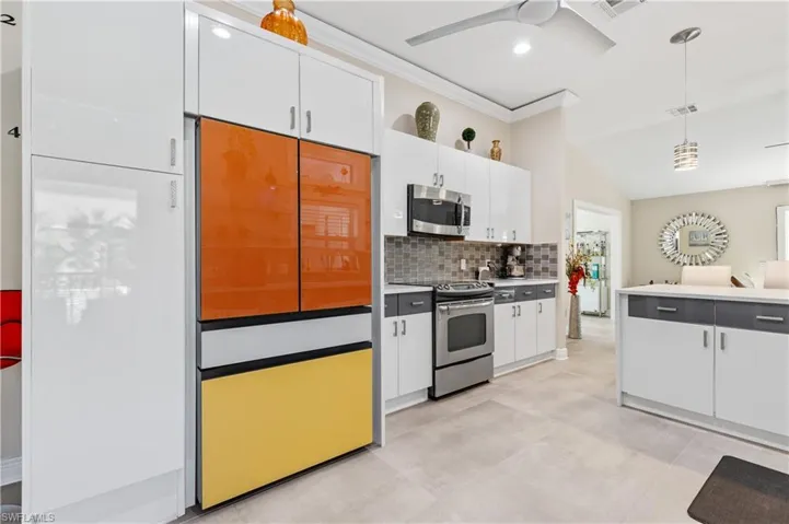 Kitchen featuring tasteful backsplash, white cabinets, Custom facing on refrigerator, and crown molding