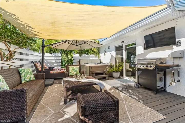 Deck featuring grilling area, a hot tub, and an outdoor hangout area