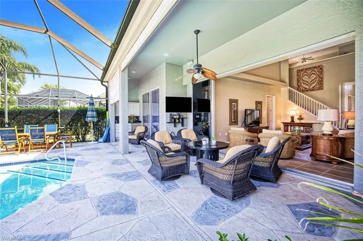 View of patio with glass enclosure, ceiling fan, an outdoor living space, and a fenced in pool