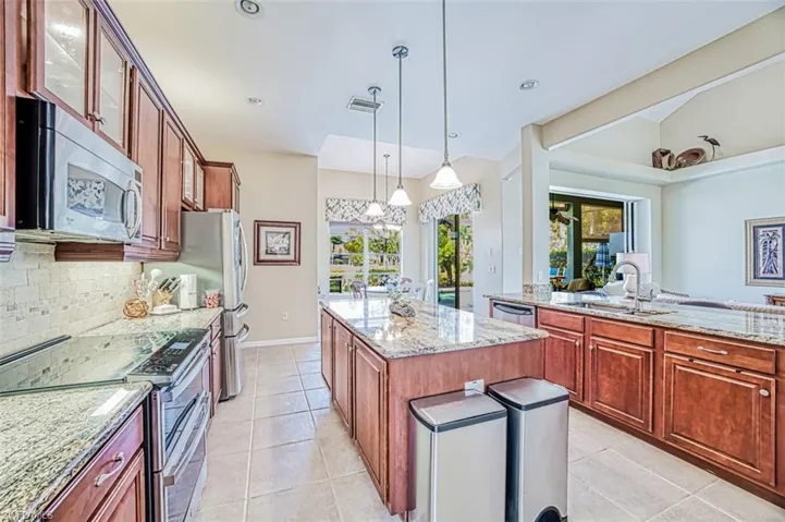 Kitchen featuring a center island, stainless steel appliances, visible vents, decorative backsplash, and a sink