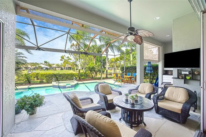 View of patio / terrace featuring ceiling fan, a lanai, and a pool with connected hot tub