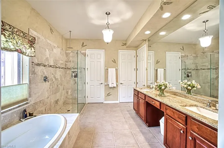Bathroom with tile patterned floors, a garden tub, a shower stall, and double vanity