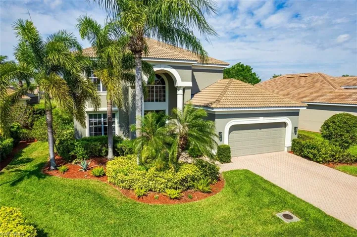 Mediterranean / spanish home featuring a garage, a front lawn, decorative driveway, and stucco siding