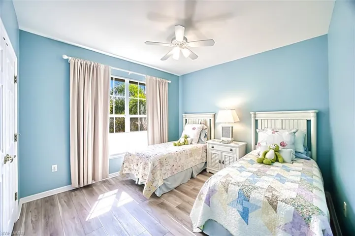 Bedroom featuring ceiling fan, baseboards, and wood finished floors