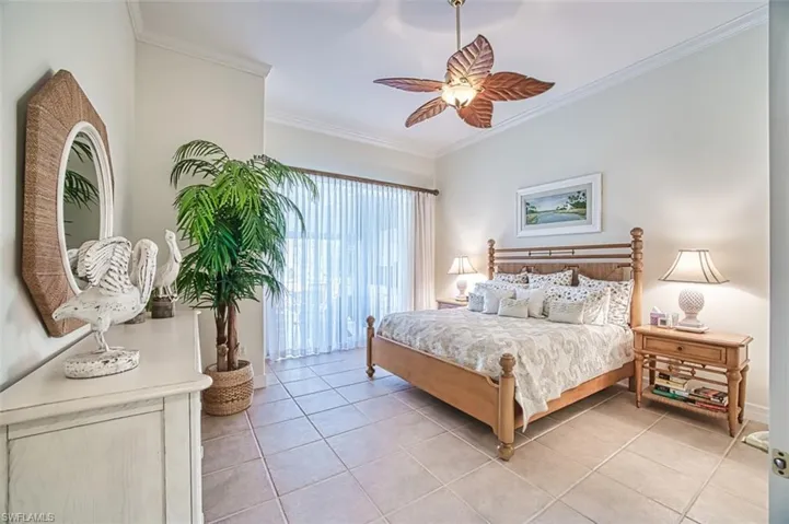 Bedroom with a ceiling fan, crown molding, and light tile patterned flooring
