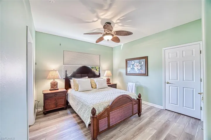 Bedroom with light wood-style floors, ceiling fan, and baseboards