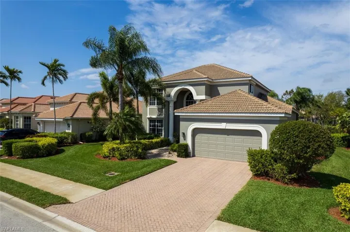 Mediterranean / spanish-style home with a garage, a tiled roof, decorative driveway, stucco siding, and a front yard