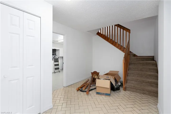 Stairway featuring a textured ceiling