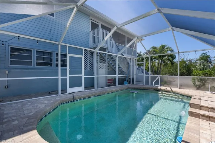Pool featuring a patio, stairs, and a lanai