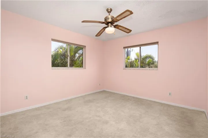 Spare room with carpet flooring, baseboards, ceiling fan, and a textured ceiling
