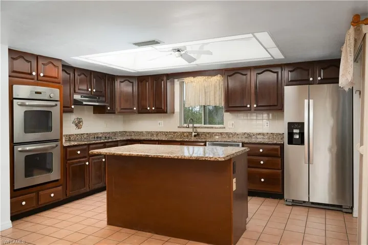 Kitchen featuring visible vents, dark brown cabinets, a ceiling fan, appliances with stainless steel finishes, and under cabinet range hood
