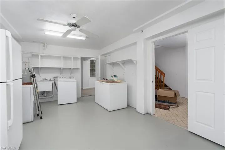 Washroom with a ceiling fan, a sink, washing machine and dryer, and laundry area
