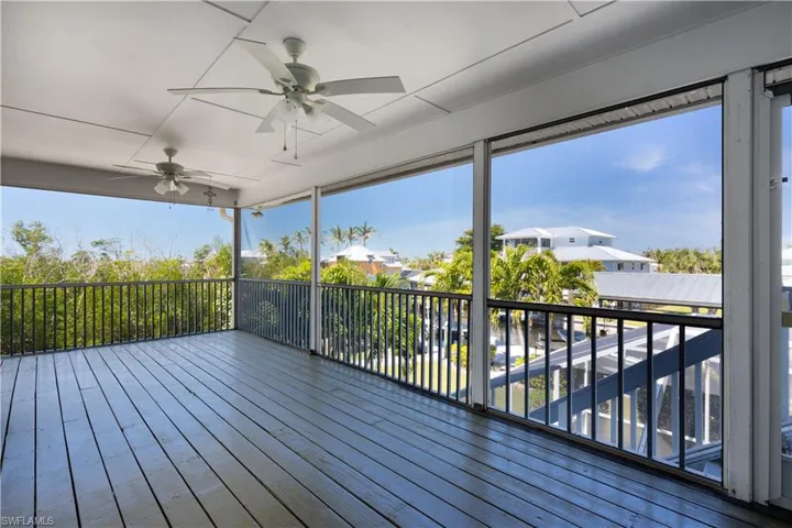 Wooden terrace with a ceiling fan and a residential view