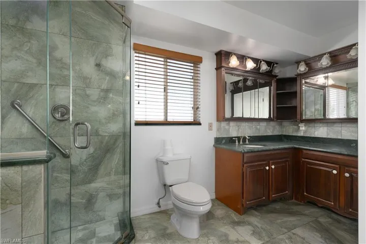 Full bathroom with a stall shower, toilet, vanity, and a healthy amount of sunlight