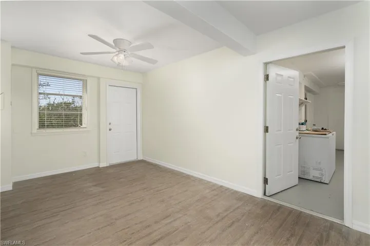Spare room with baseboards, wood finished floors, beam ceiling, and a ceiling fan
