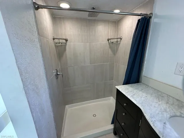 Bathroom with a shower with shower curtain and vanity