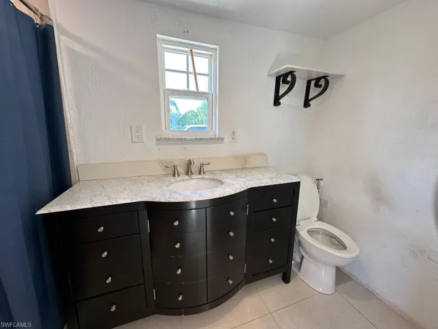 Bathroom with vanity, toilet, and tile patterned floors