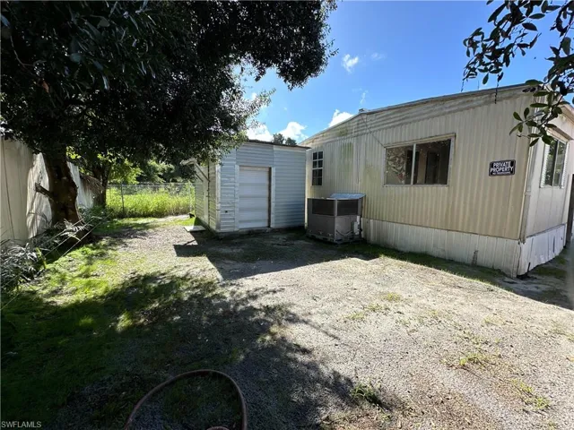 View of yard featuring an outdoor structure, a garage, and central air condition unit