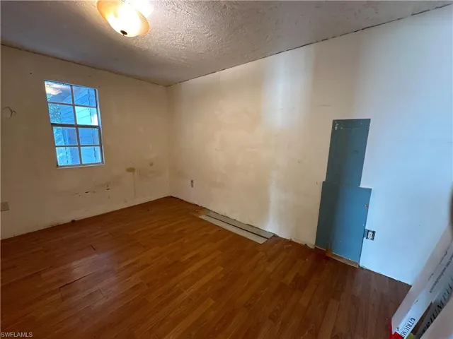 Unfurnished room with wood-type flooring and a textured ceiling