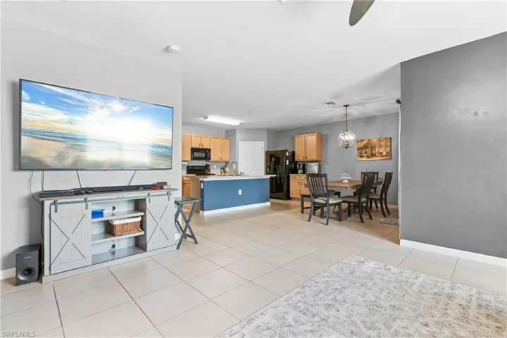 Living room featuring sink, an inviting chandelier, and light tile patterned floors