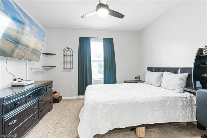 Bedroom with light carpet and ceiling fan