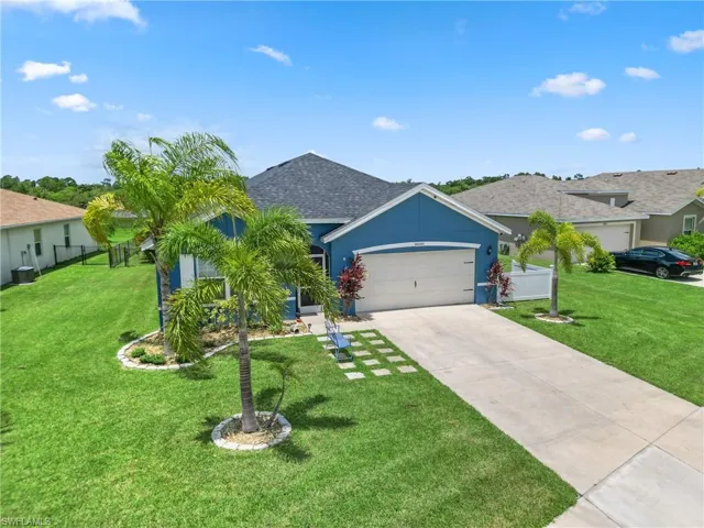 Single story home with a garage and a front lawn