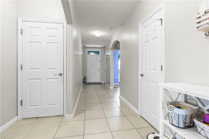 Hallway featuring light tile patterned floors