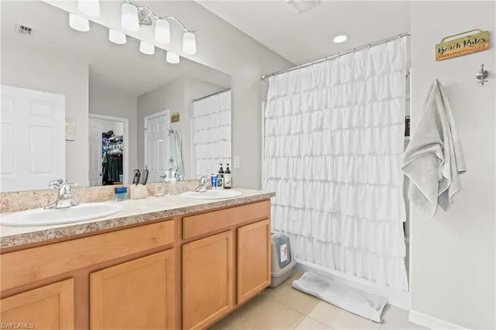 Bathroom featuring double vanity and tile patterned floors