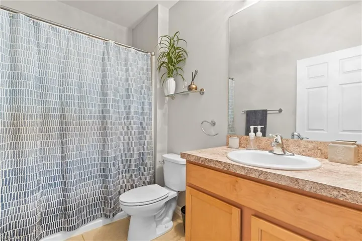 Bathroom with vanity, toilet, and tile patterned flooring