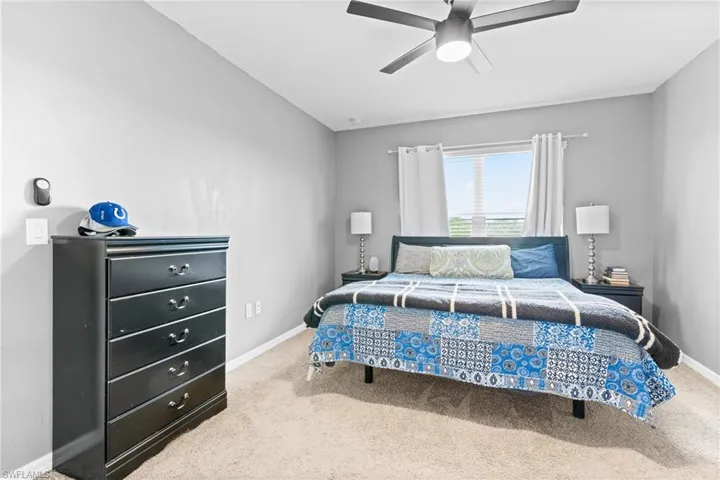 Carpeted bedroom featuring ceiling fan