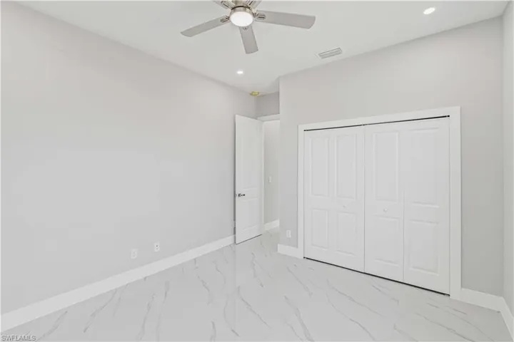 Third bedroom with light marble finish flooring, a closet, a ceiling fan, and recessed lighting