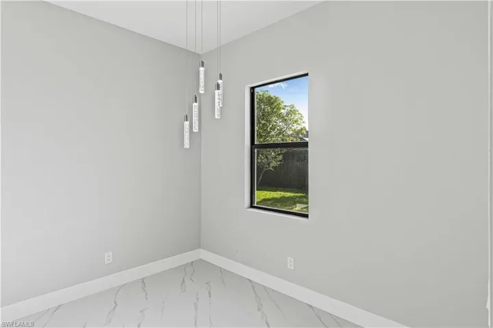 Empty room with marble look tiles and baseboards