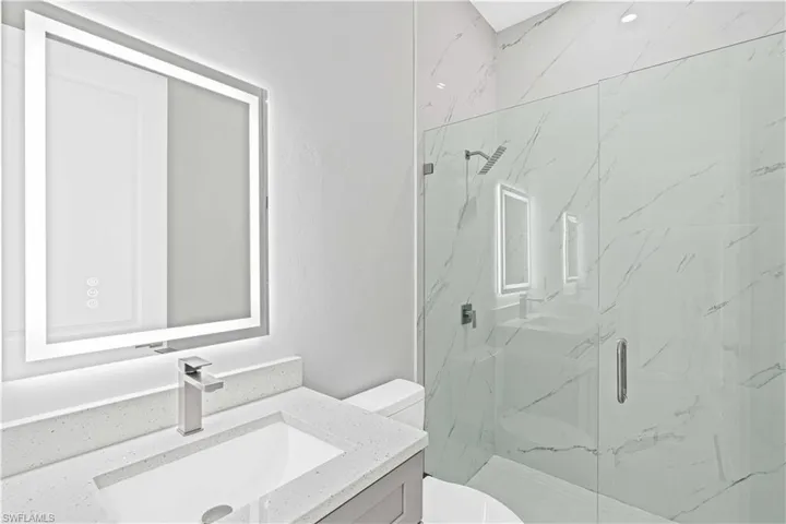 Second full bathroom featuring vanity and a marble finish shower