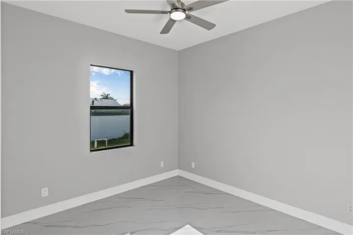 Third bedroom featuring baseboards and light marble finish flooring