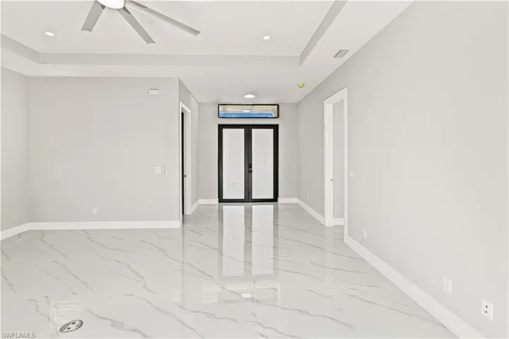 Empty room with french doors, recessed lighting, light marble finish flooring, and ceiling fan