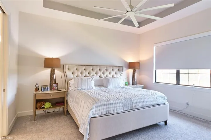 Master Bedroom with carpet, a ceiling fan, and a tray ceiling