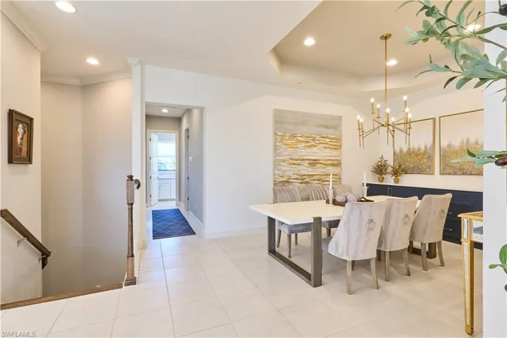 Dining space featuring recessed lighting, light tile patterned floors, a tray ceiling, and a chandelier