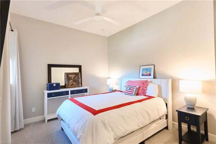 Carpeted bedroom featuring ceiling fan and baseboards