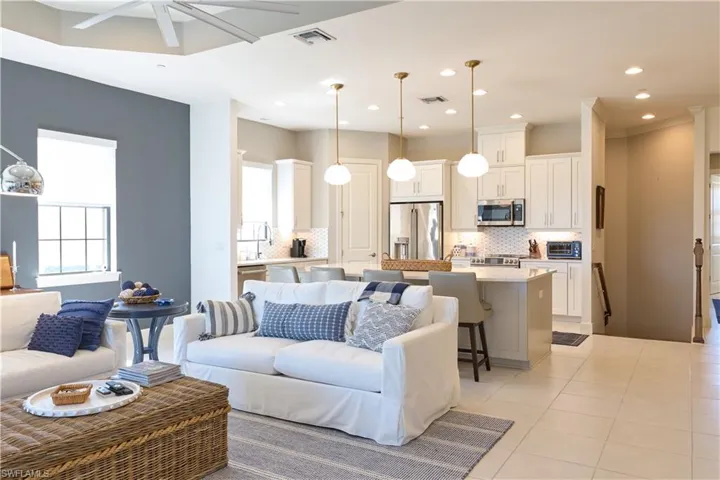 Living area with light tile patterned floors, a ceiling fan, and recessed lighting