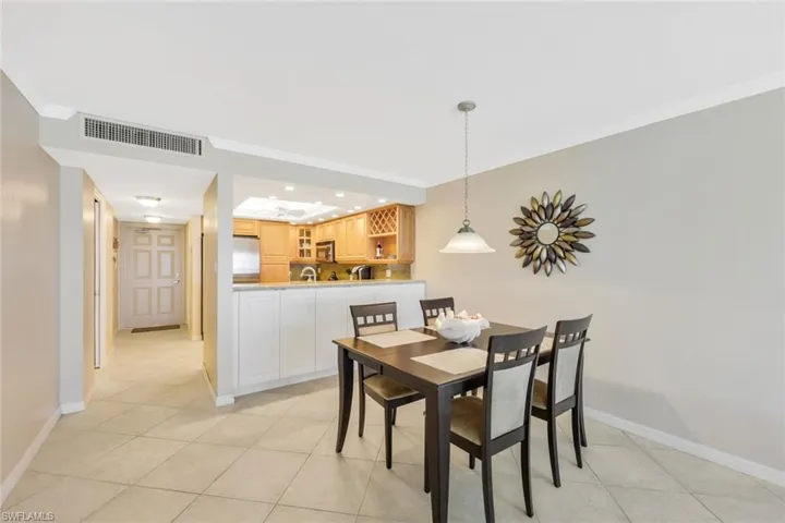 Dining area with ornamental molding and light tile floors
