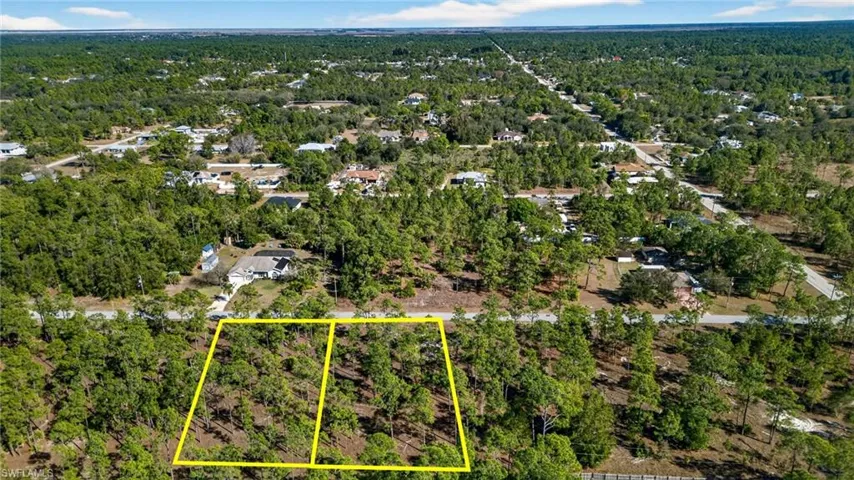 Aerial view of property's location featuring property boundaries highlighted and a heavily wooded area