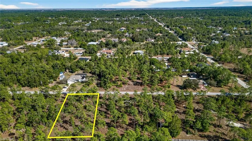 Aerial view of property's location featuring a heavily wooded area and property parcel outlined