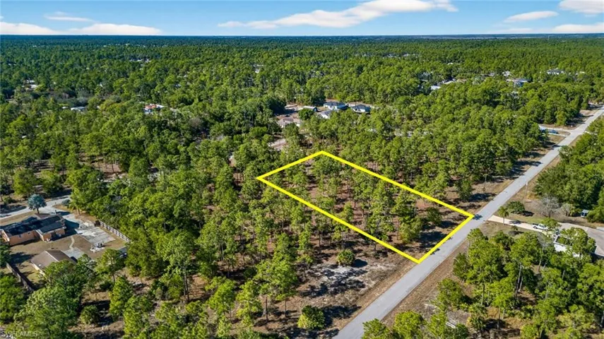 Aerial view of property's location featuring a heavily wooded area and property parcel outlined